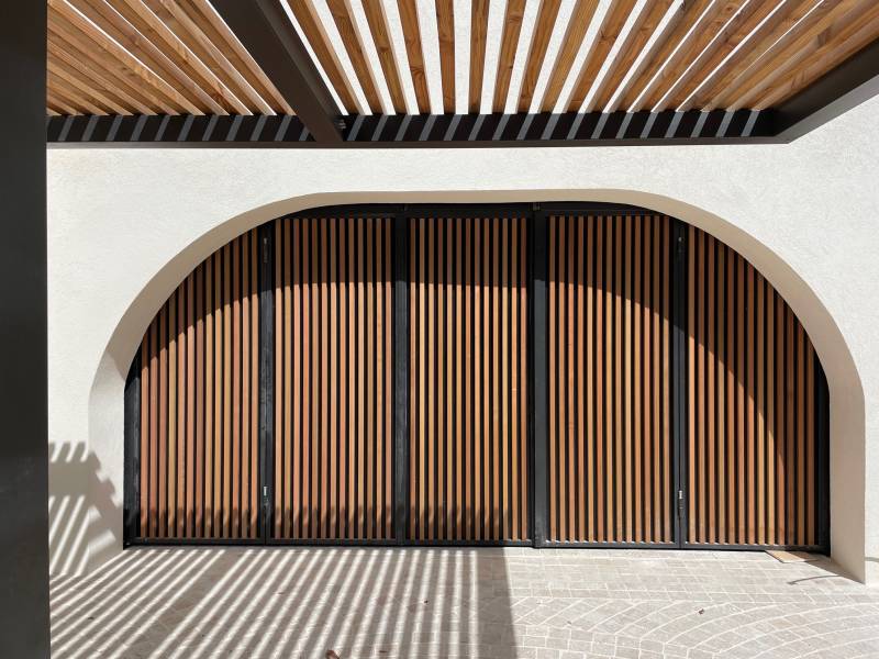 Aménagement d'un extérieur avec des pavés en pierre naturelle et fontaine sur mesure devant le garage d'une grande villa à Cassis